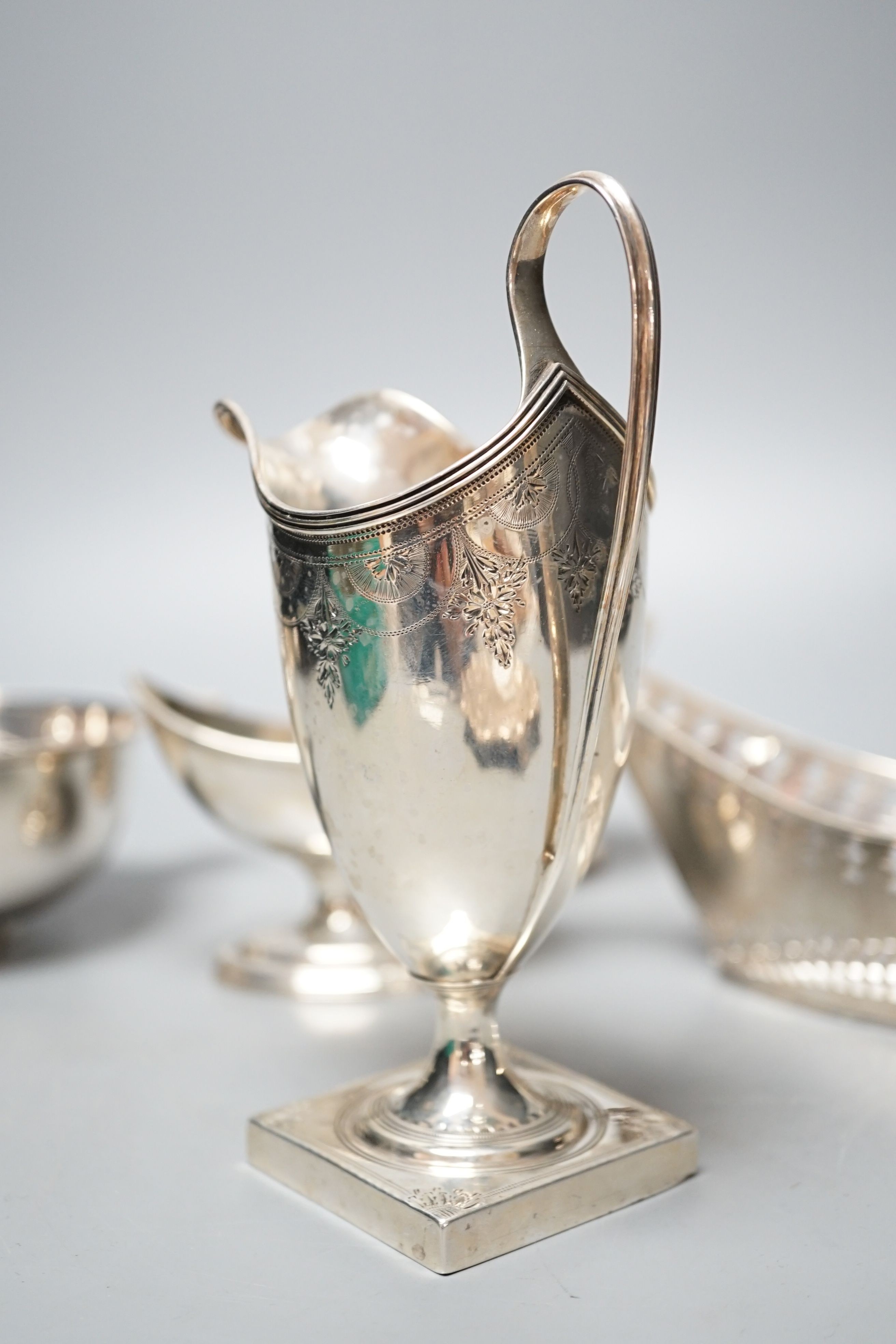 A mixed collection of silver to include a Scottish quaich, a pair of George III boat shaped salts, a George III silver helmet shaped cream jug and a pierced boat-shaped bowl, 17oz.
